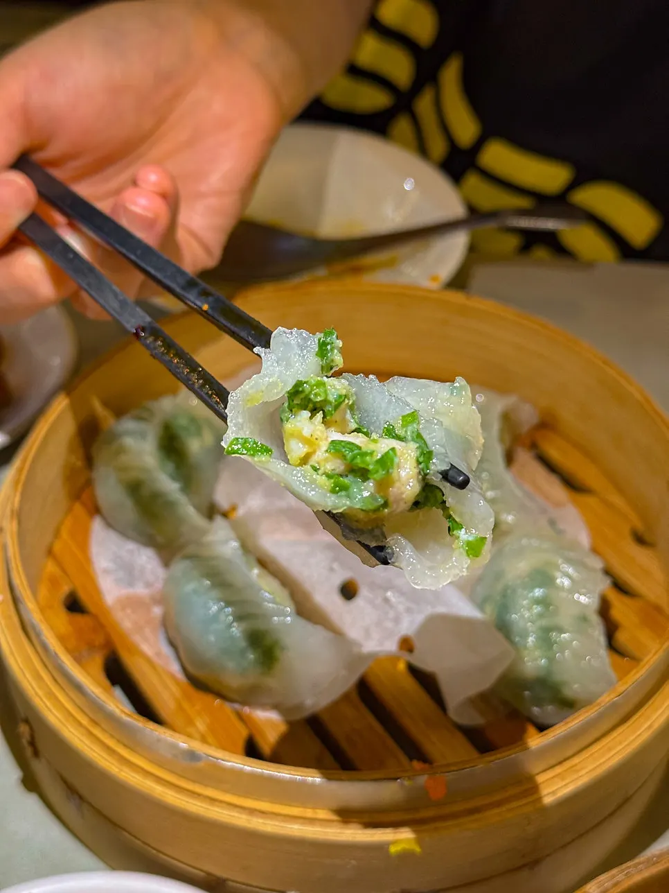 A crystal dumpling cut in half showing shrimp and chive filling
