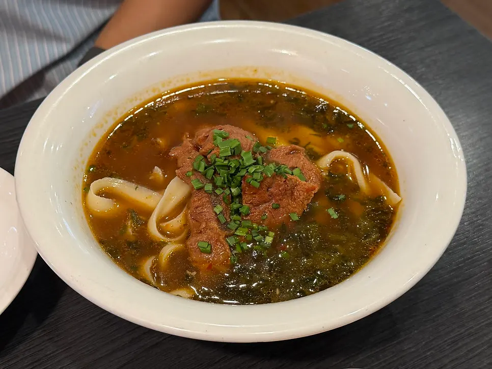 Close-up of beef dosakmyeon topped with big chunks of beef