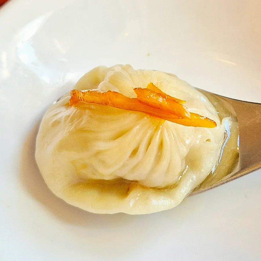 Xiaolongbao topped with ginger dipped in soy sauce