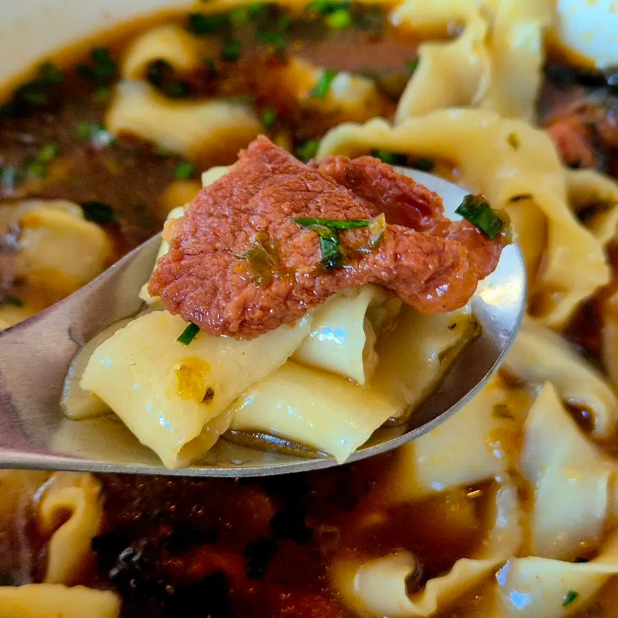 House-made knife-shaved noodles lifted with chopsticks