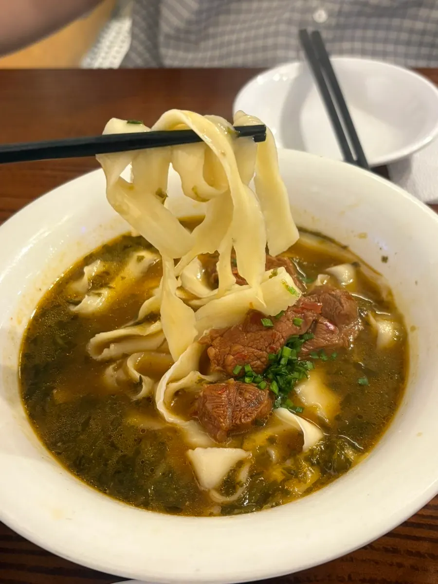 Chewy noodles lifted up from the beef noodle soup