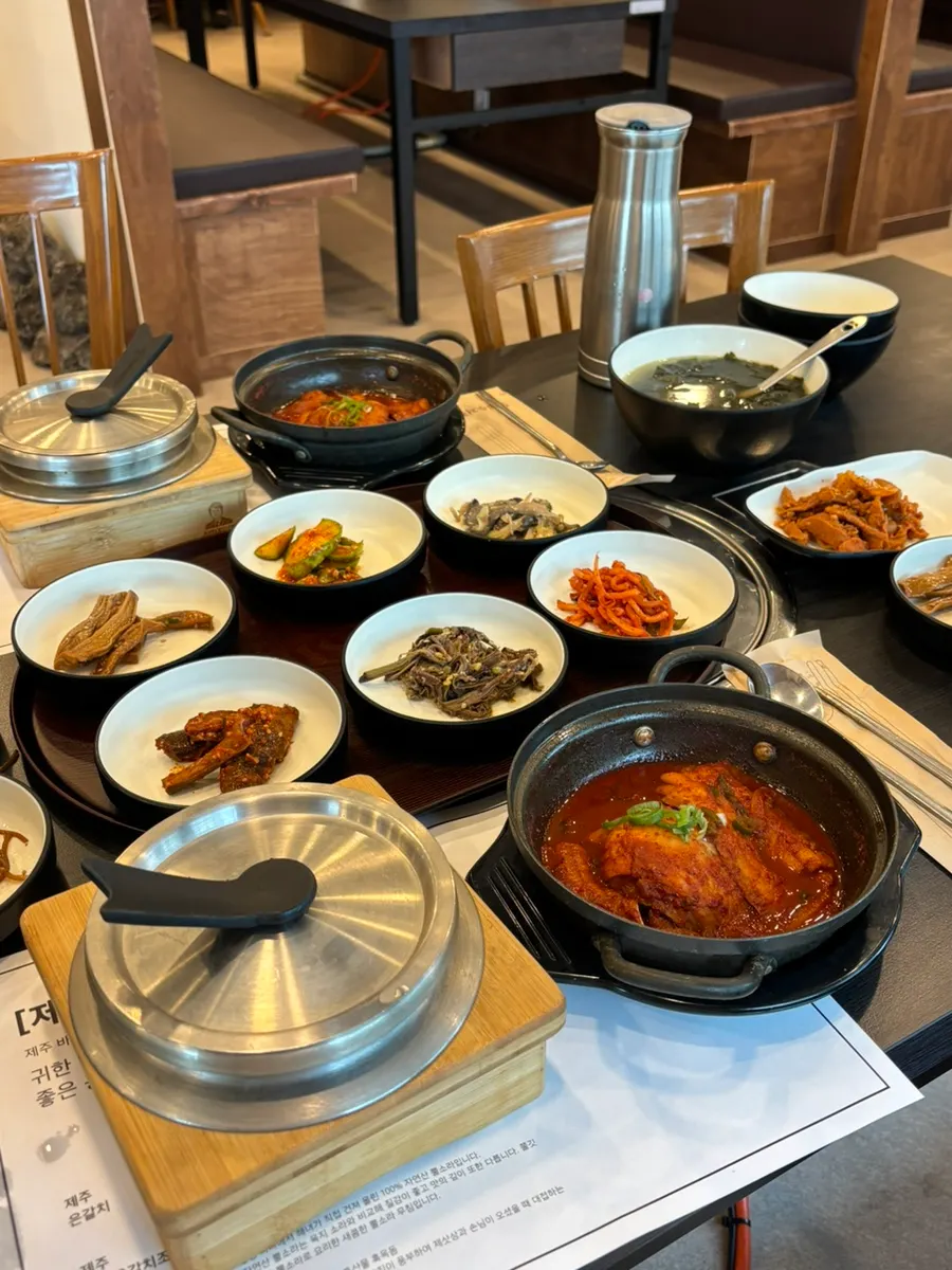 A plate of chicken, japchae, and salad brought to the table