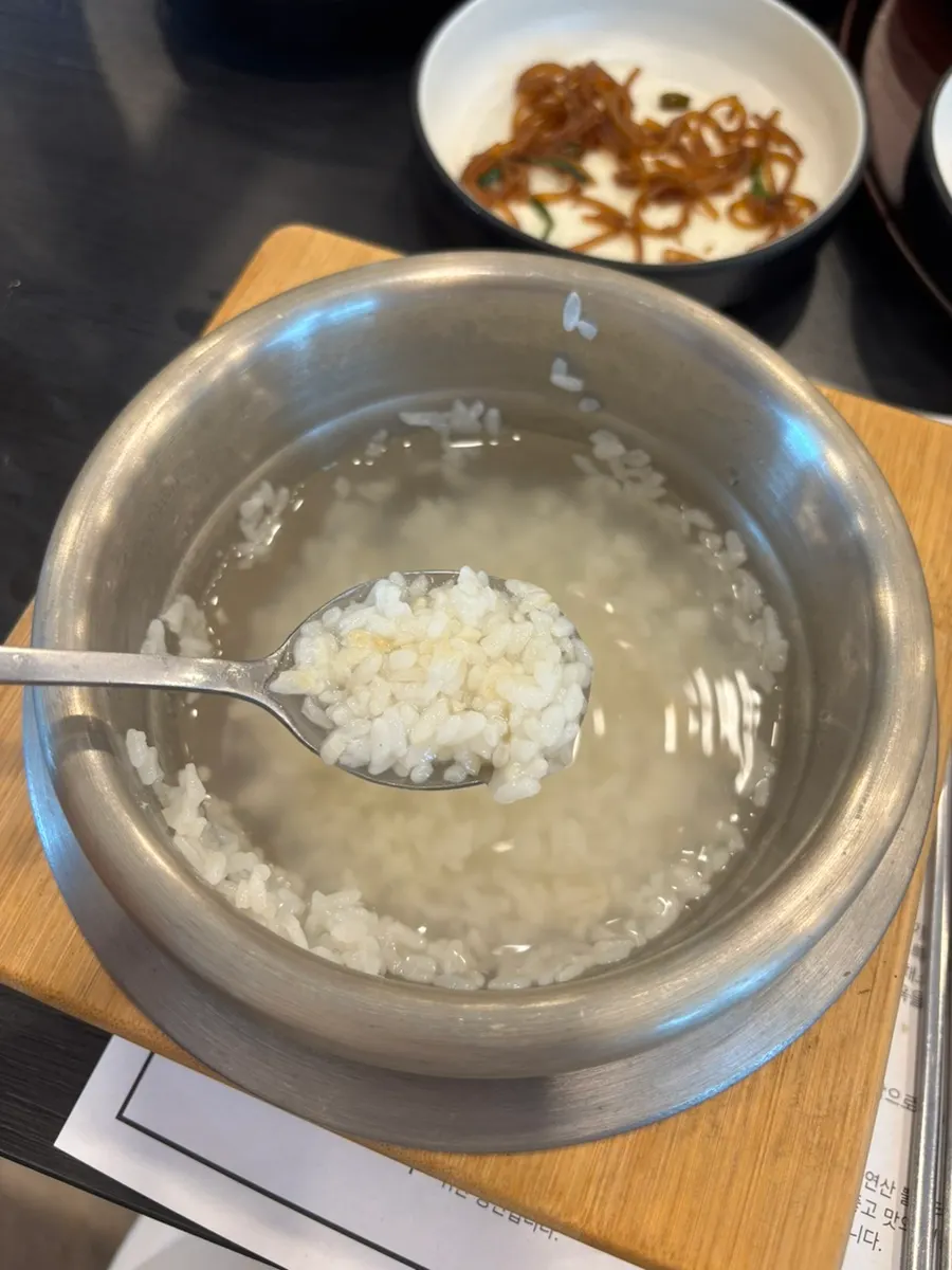A spoonful of pot rice eaten with pork stir-fry