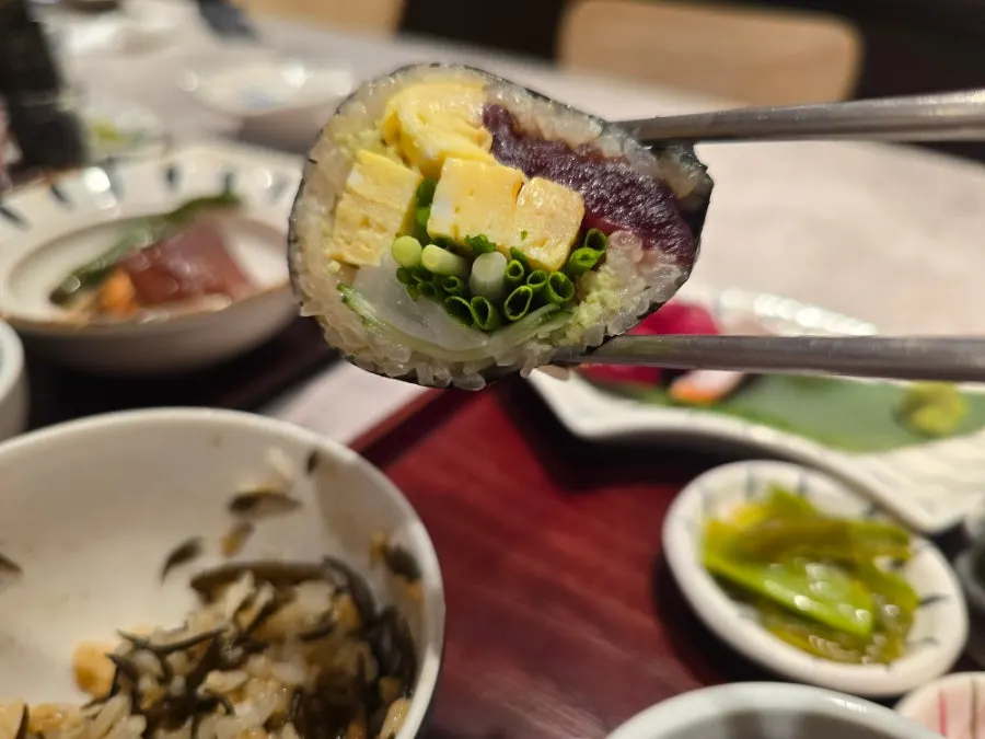 Table spread with sashimi, tot-bap, and simmered dishes