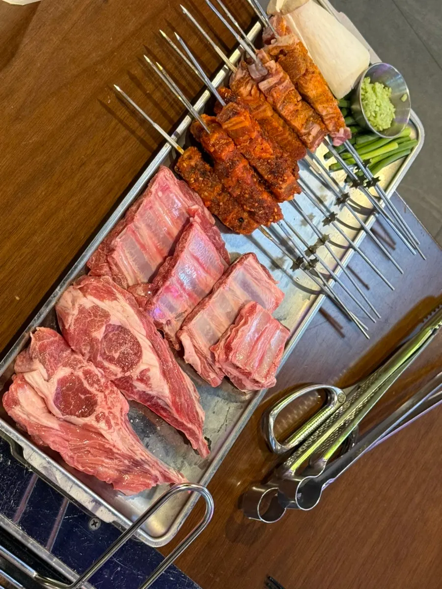 Raw lamb ribs and bone-in lamb ribs served on a silver tray