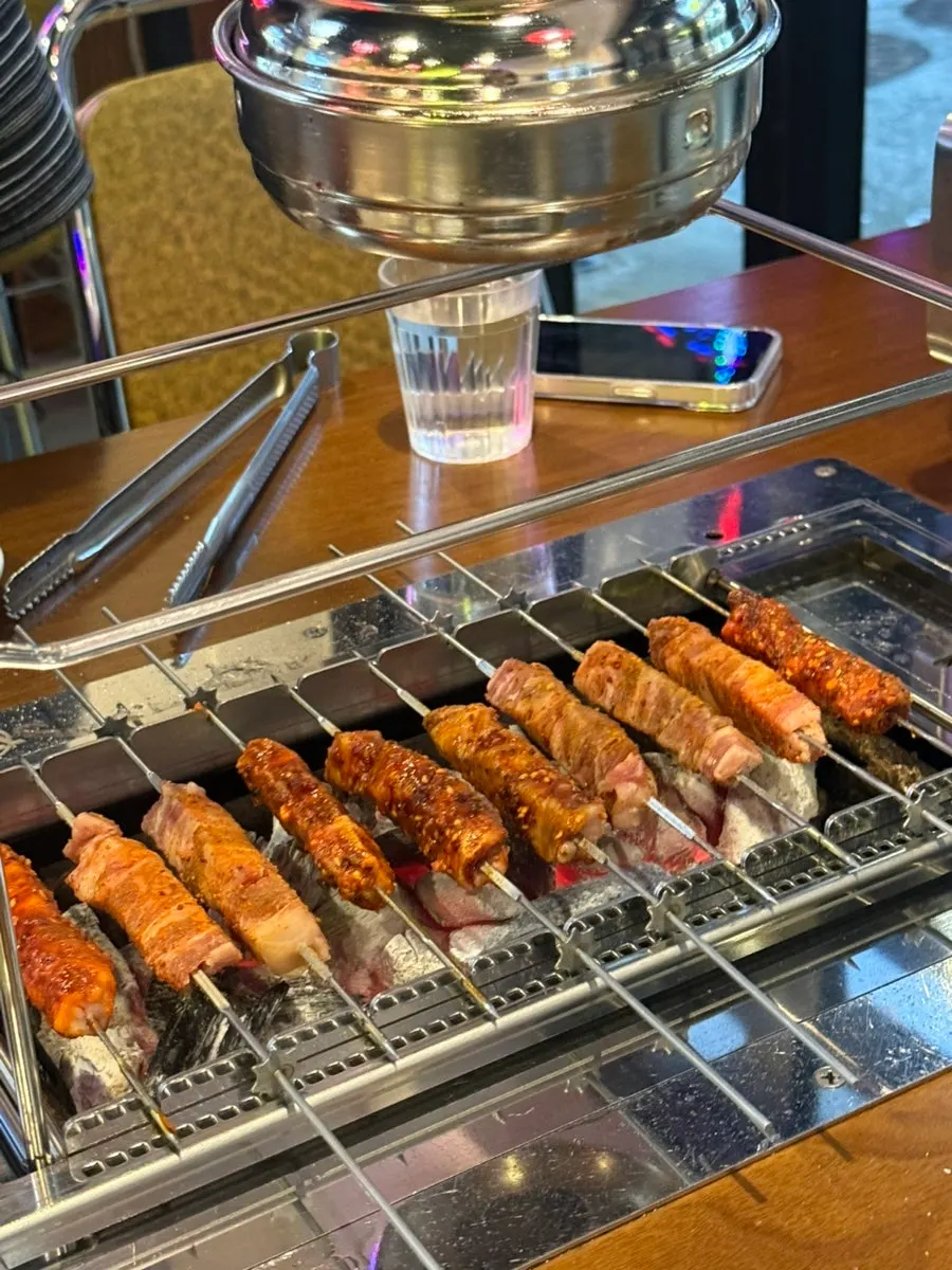 Lamb skewers turning and cooking on the grill