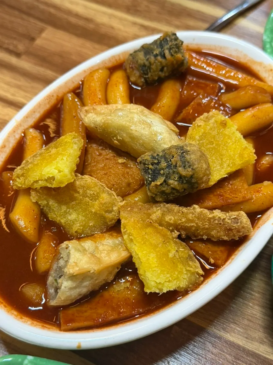 Fried snacks dunked in tteokbokki sauce