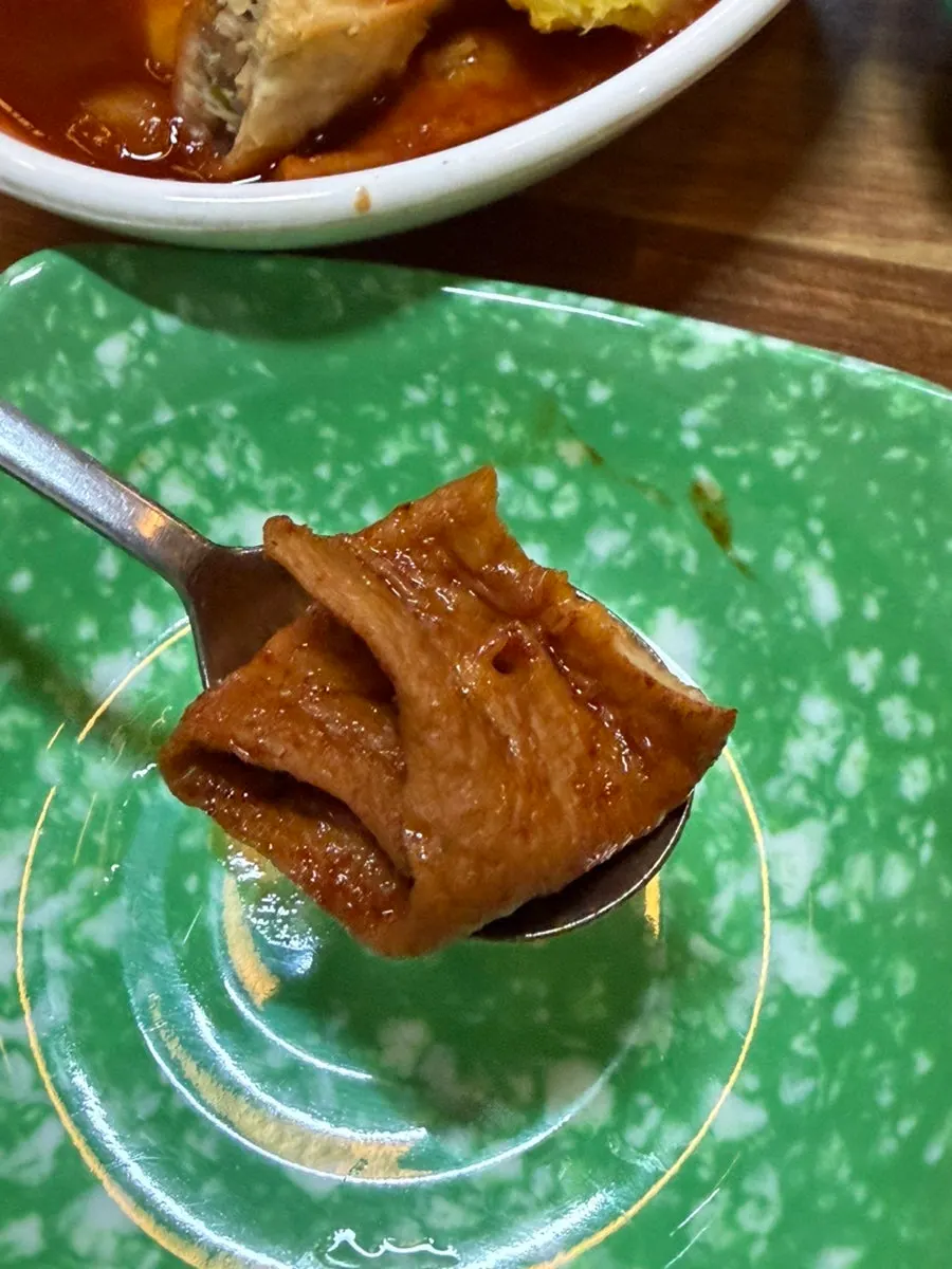Chewy rice cake lifted out of the tteokbokki sauce