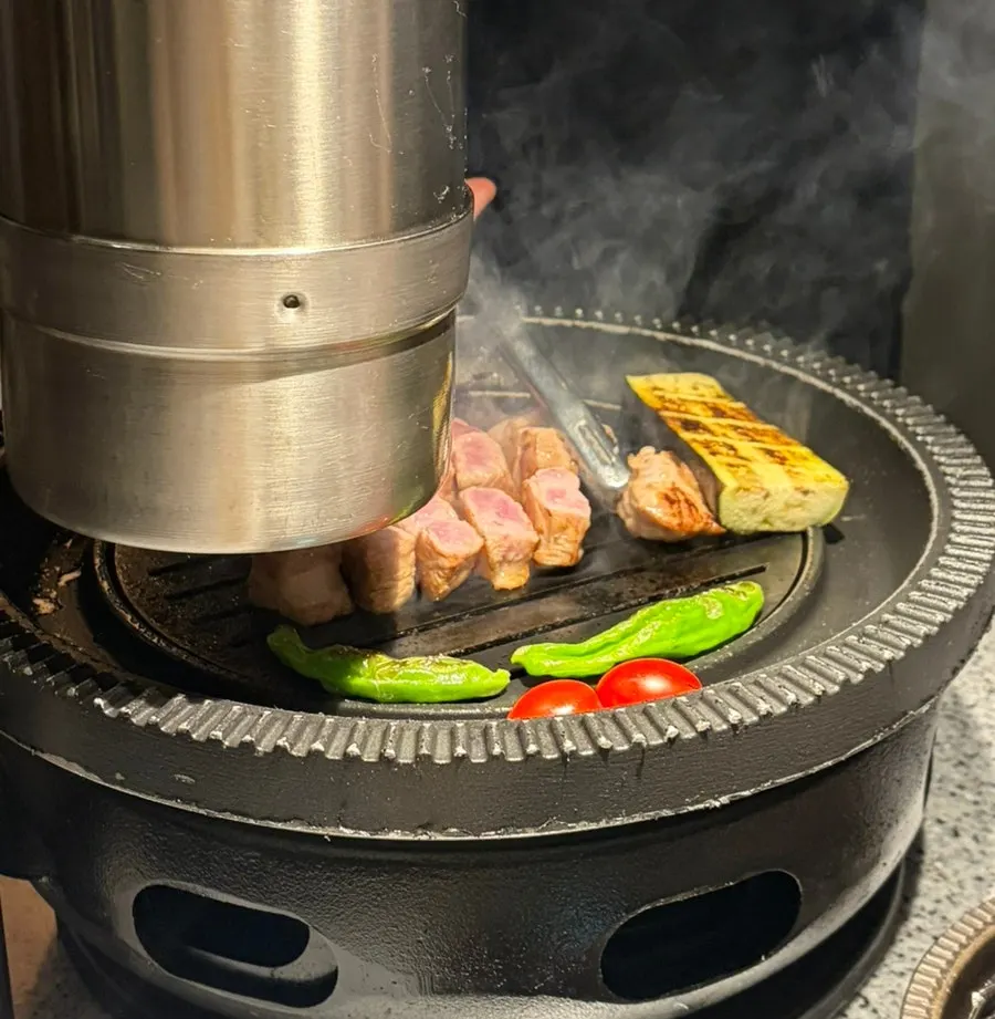 숯불 위에서 직원이 굽는 돼지고기