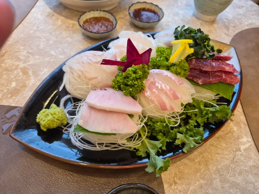 A plate of assorted sashimi including tuna and sea bream