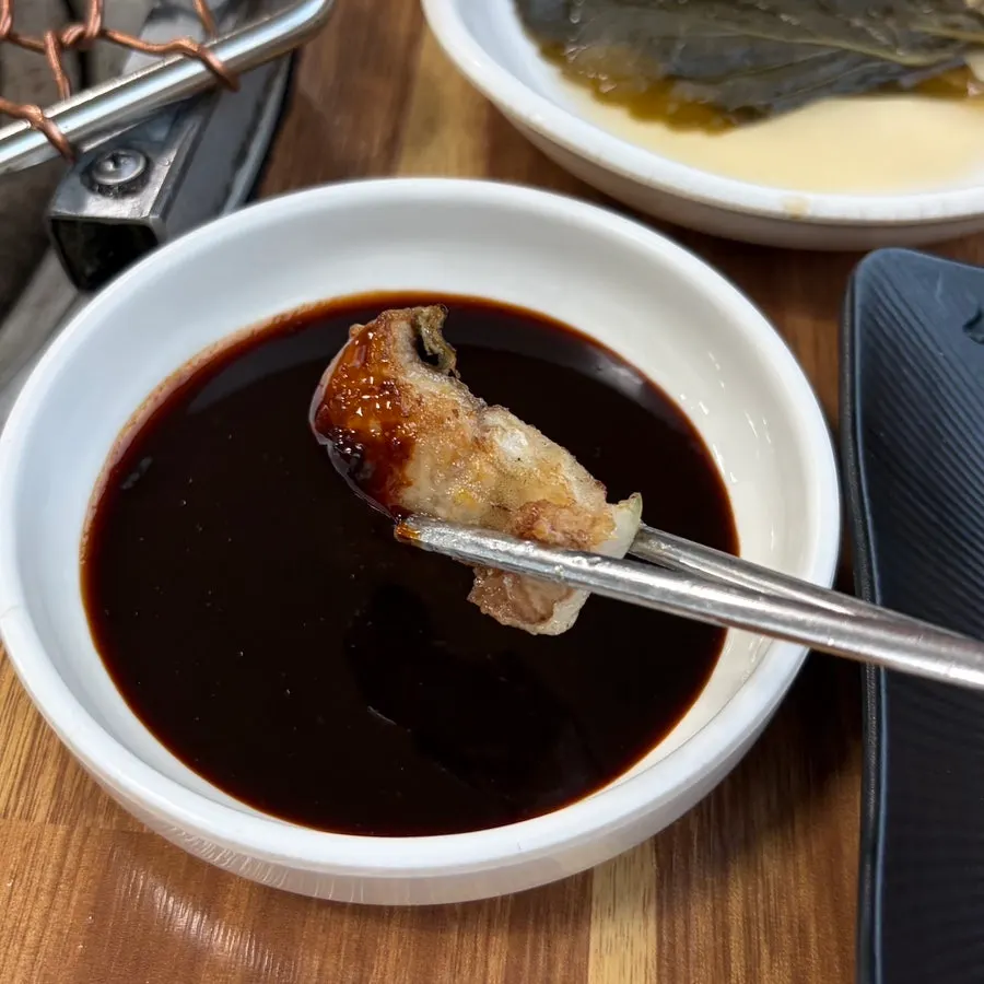 A piece of charcoal-grilled eel with shredded ginger