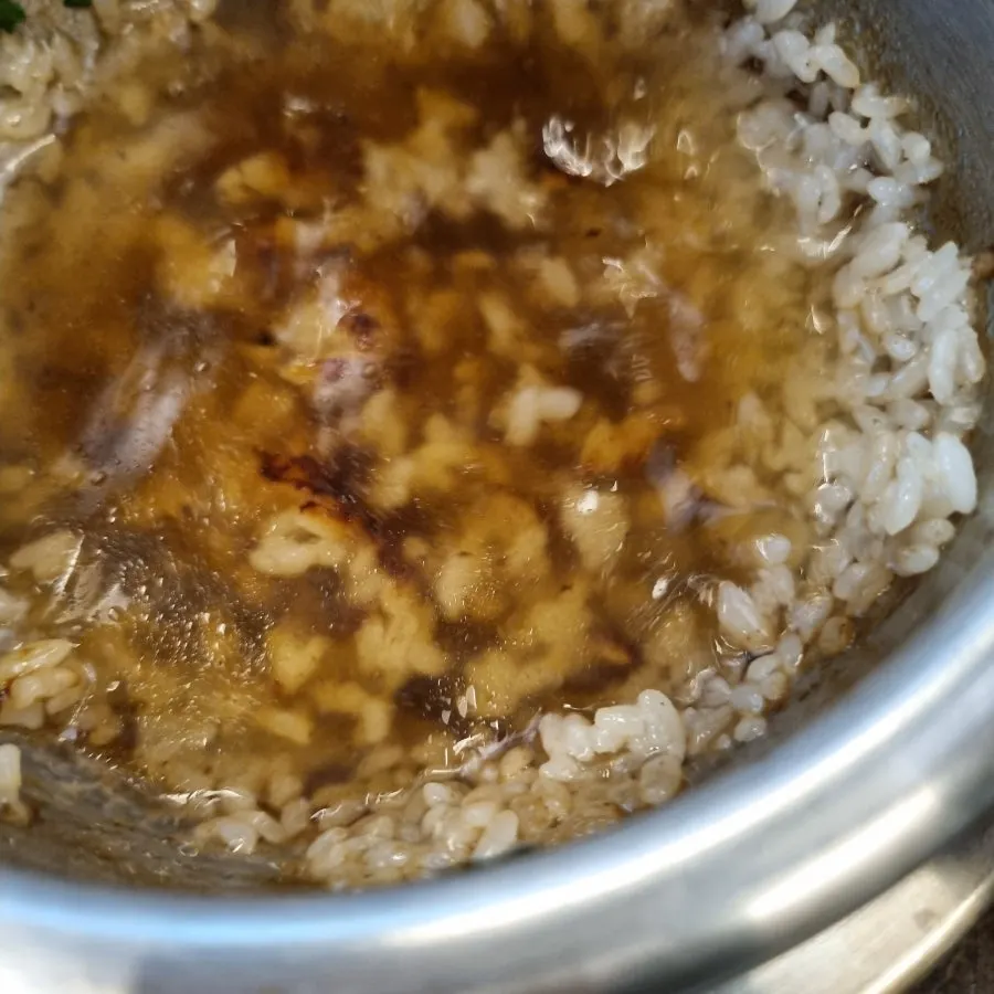 Pouring water over scorched rice in the pot