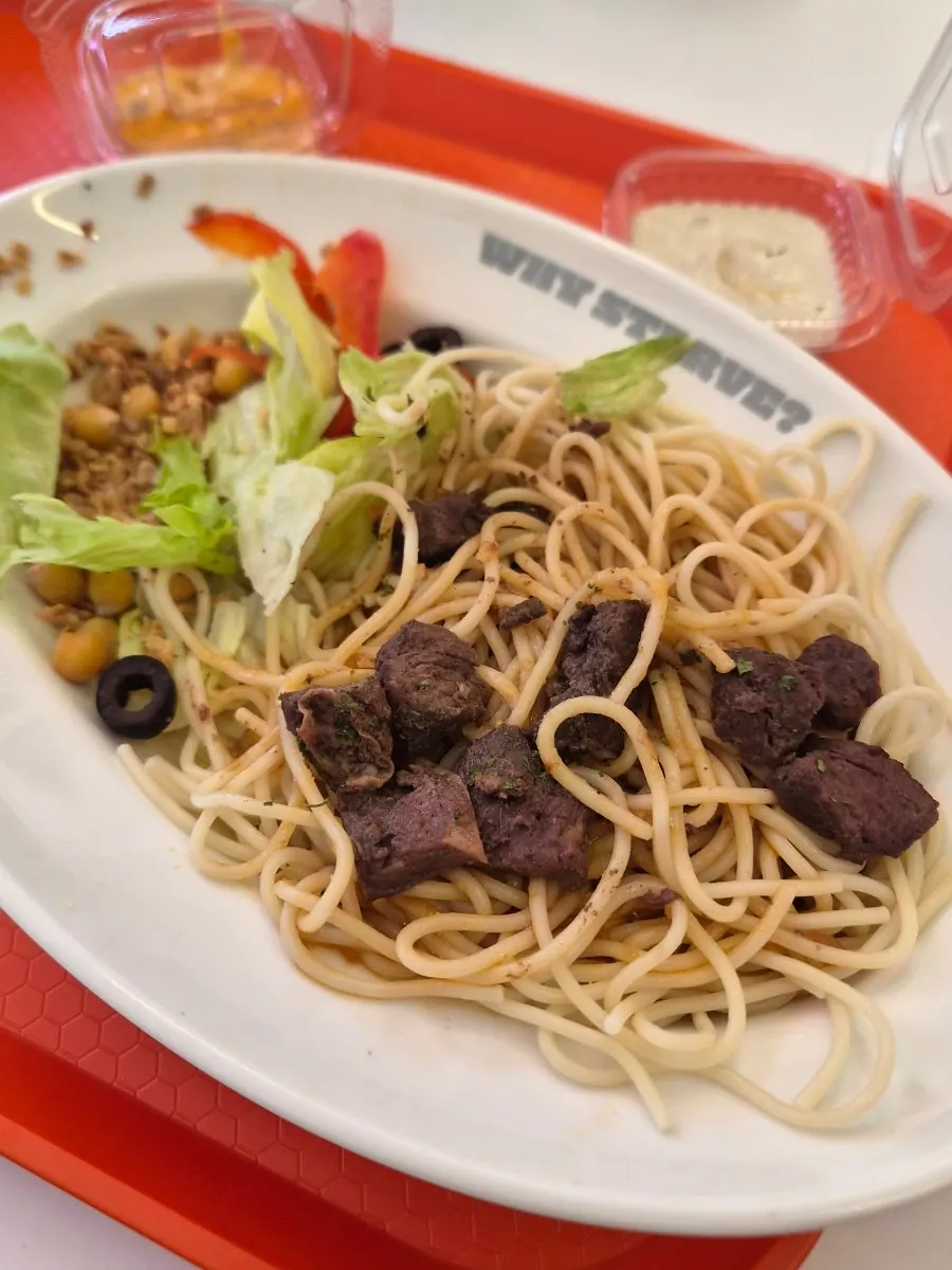 Seasoned pasta noodles layered beneath the veggies