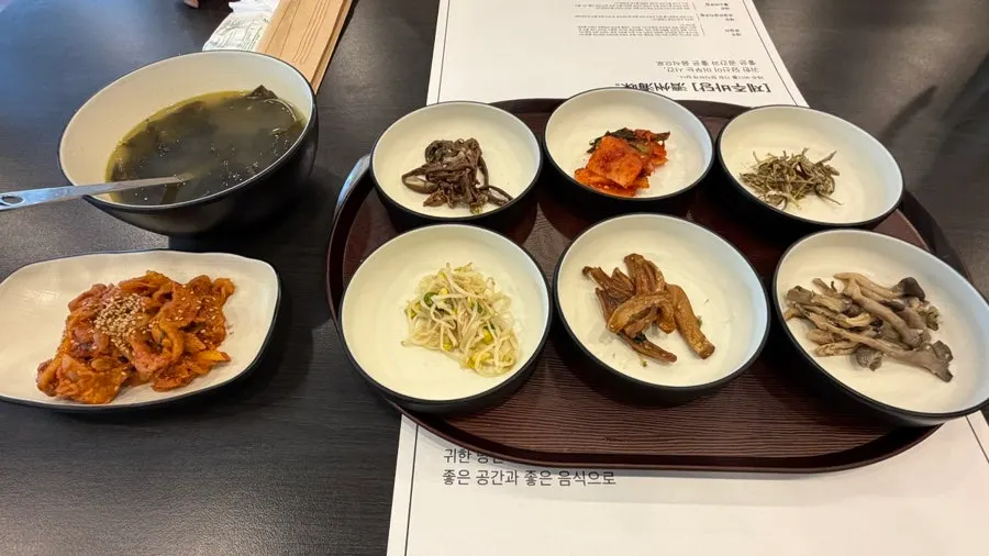 Basic table setting with side dishes and spicy pork stir-fry