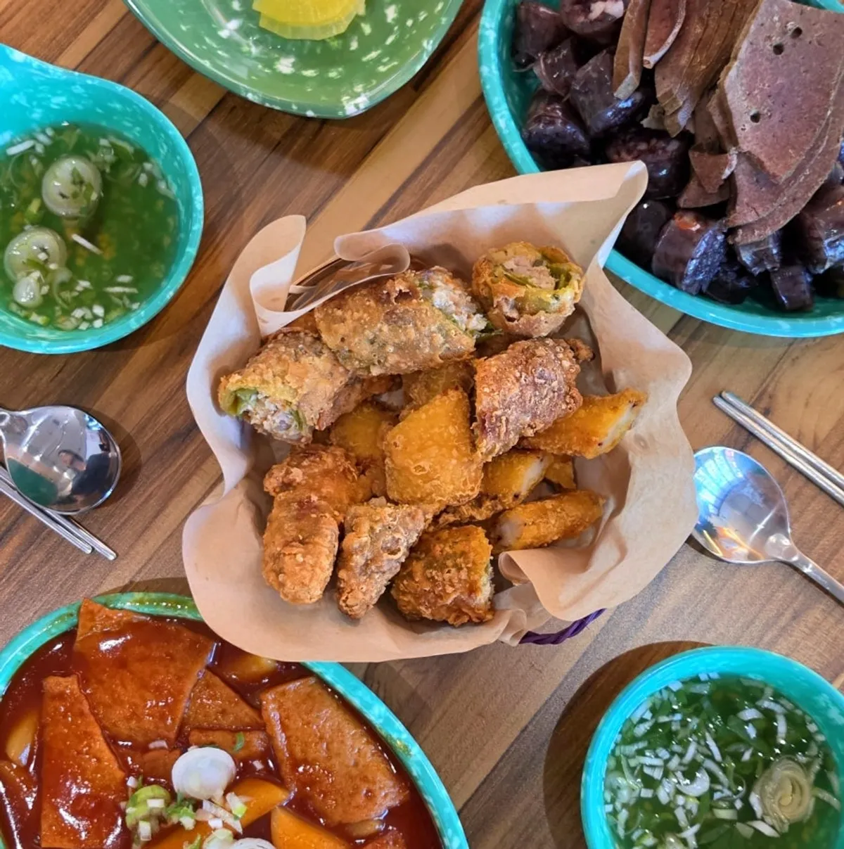 A spread of soupy tteokbokki and fried snacks