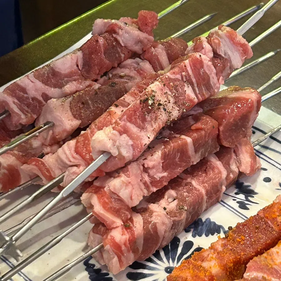 Close-up of pepper-seasoned 5-layer raw lamb skewers