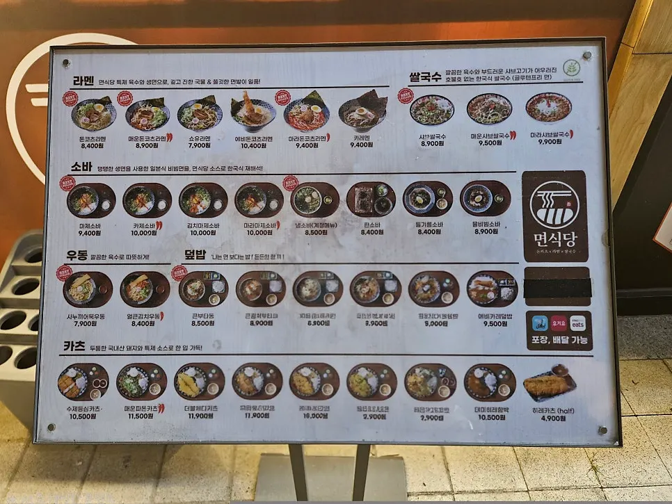 Menu board showing ramen, pho, soba, udon, rice bowls, and katsu