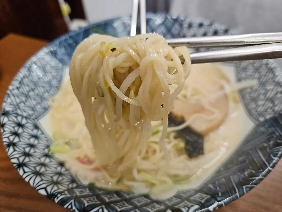Fresh noodle strands of the tonkotsu ramen lifted up