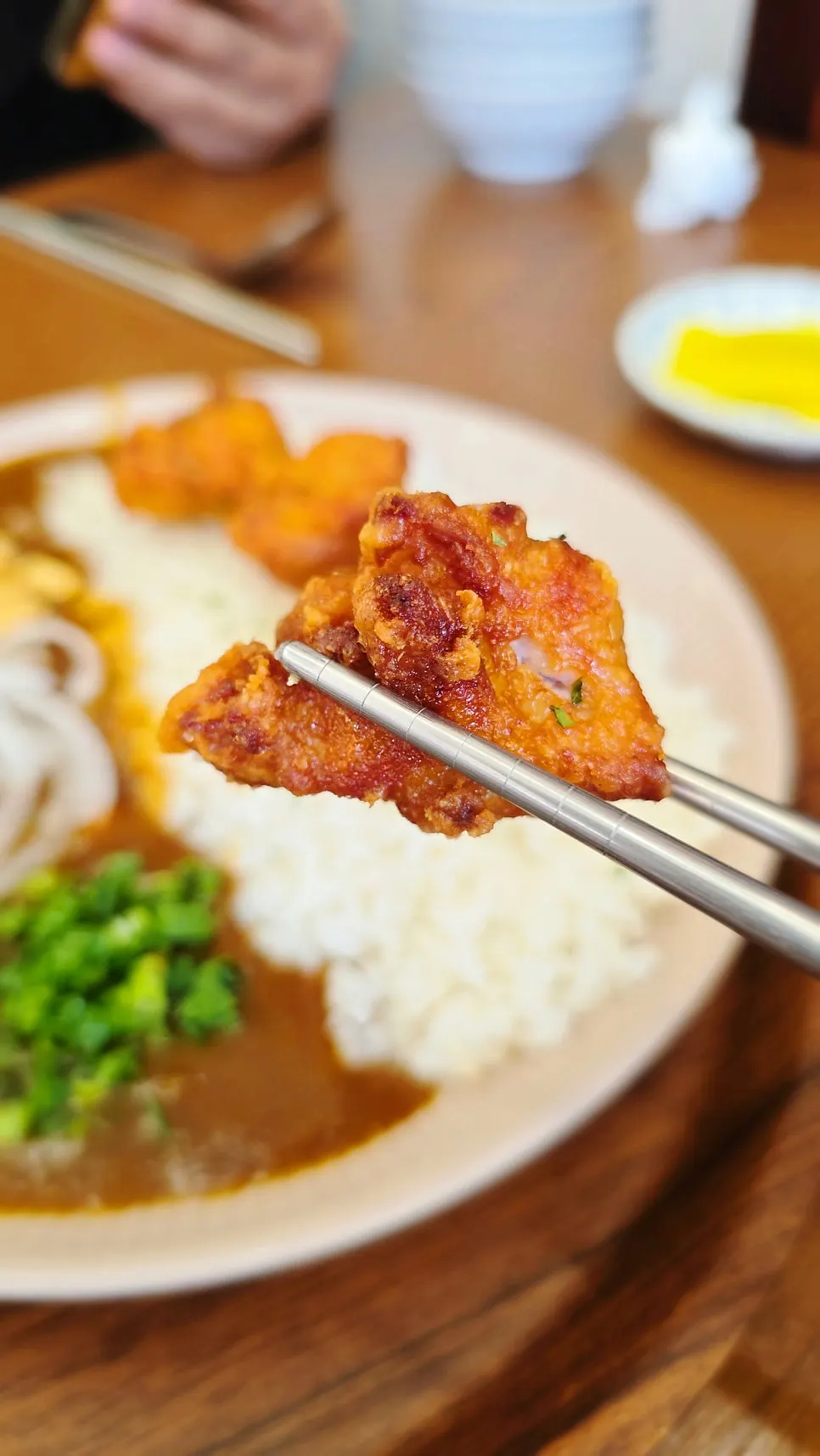 A bite taken from the karaage curry rice bowl