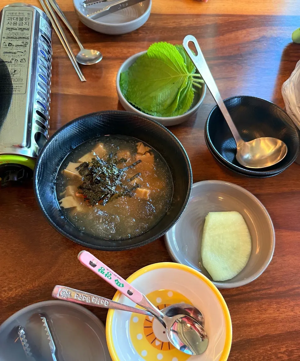 Side dishes of acorn jelly, pickled radish, and perilla leaves