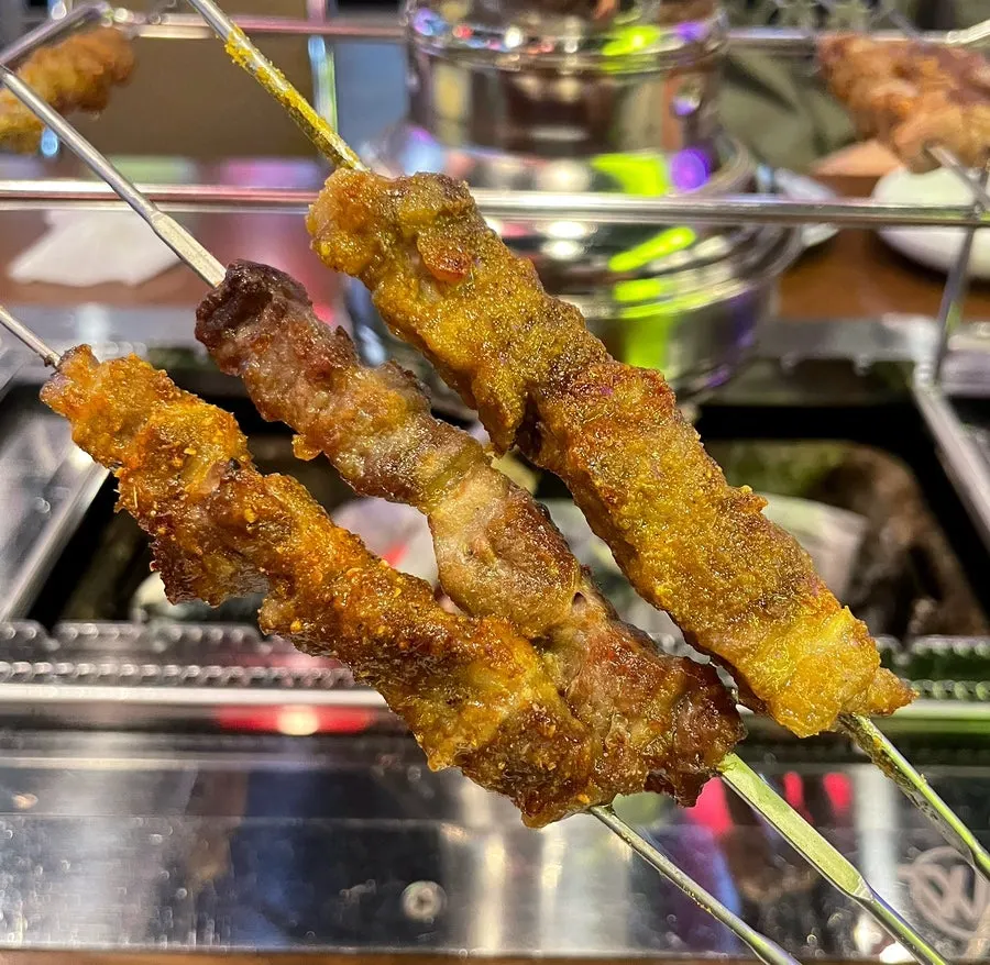 Lamb skewers grilling over charcoal