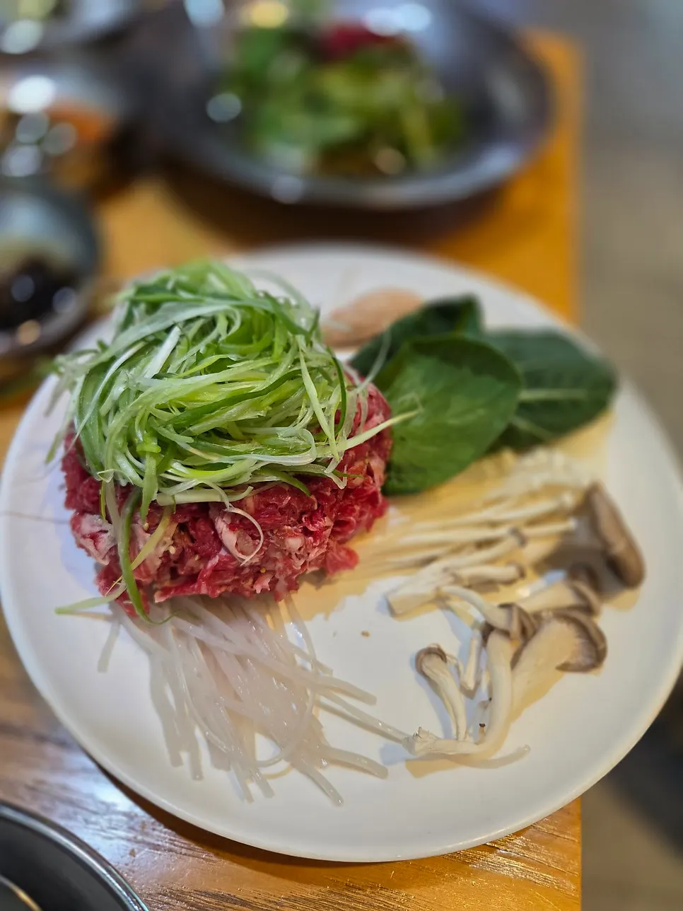 A spread of kimchi, dressed lettuce and other side dishes