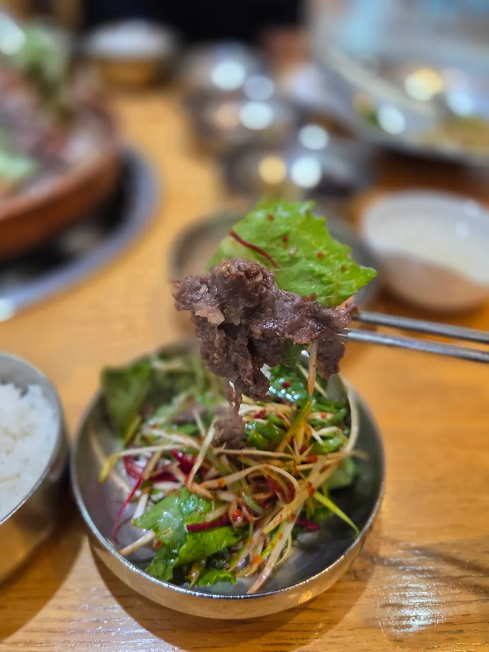 Hanwoo raw bulgogi grilling in the middle of the copper plate