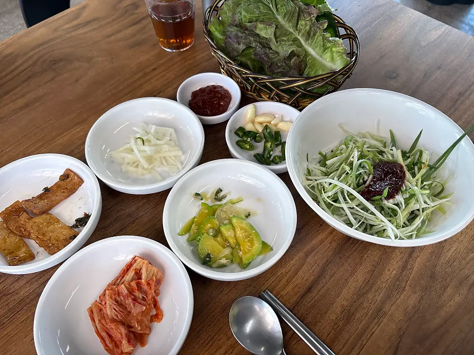 Table setting with lettuce wraps and scallion salad