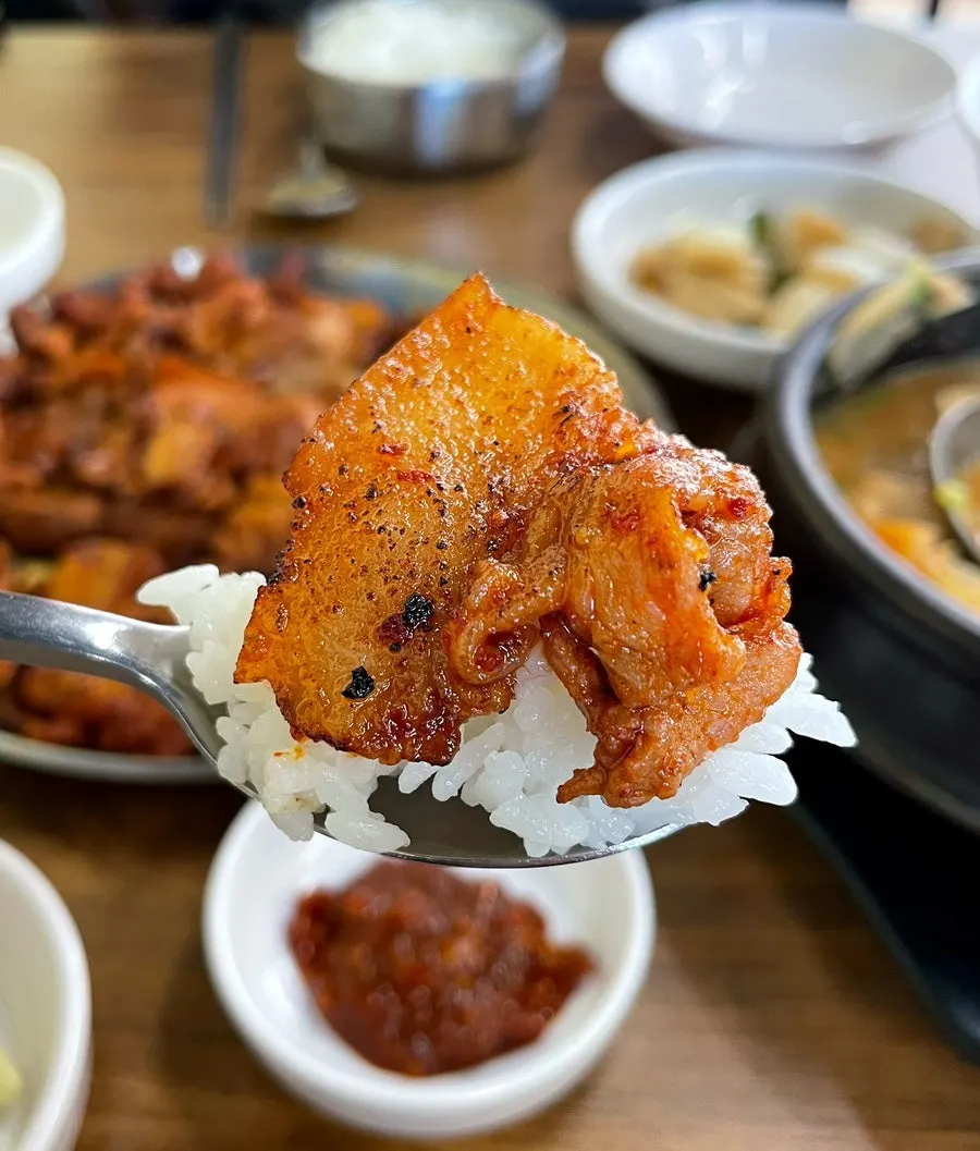 젓가락으로 집어 든 연탄고추장구이 한 점