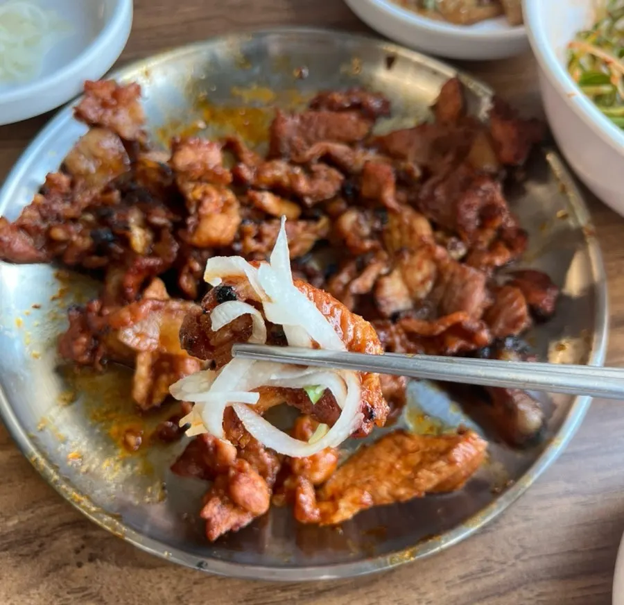 A piece of gochujang pork topped with radish pickle