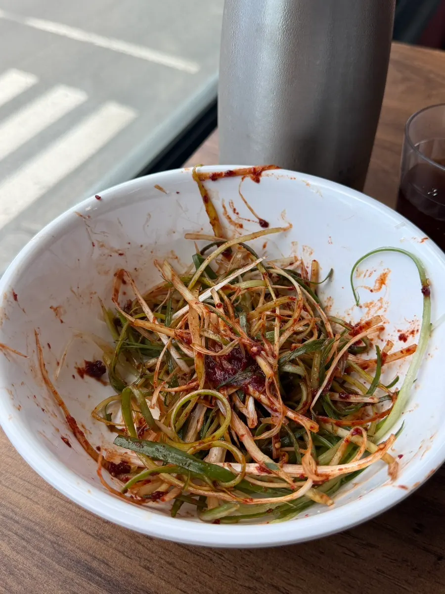 A bite of charcoal gochujang pork wrap