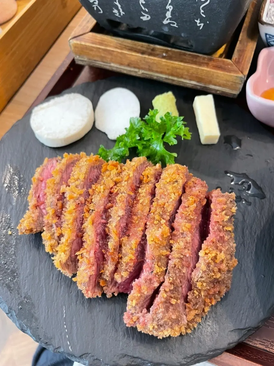 A piece of gyukatsu being grilled on the mini brazier