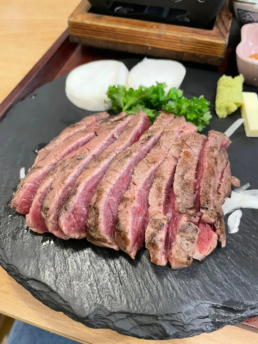 A piece of steak being grilled on the brazier