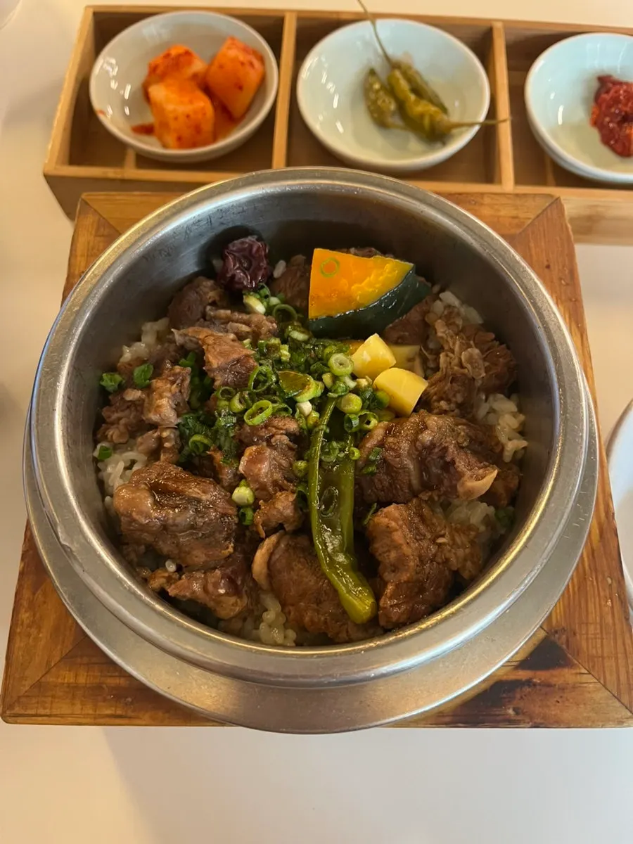 Beef short rib pot rice dengan topping daun bawang, labu, dan kurma