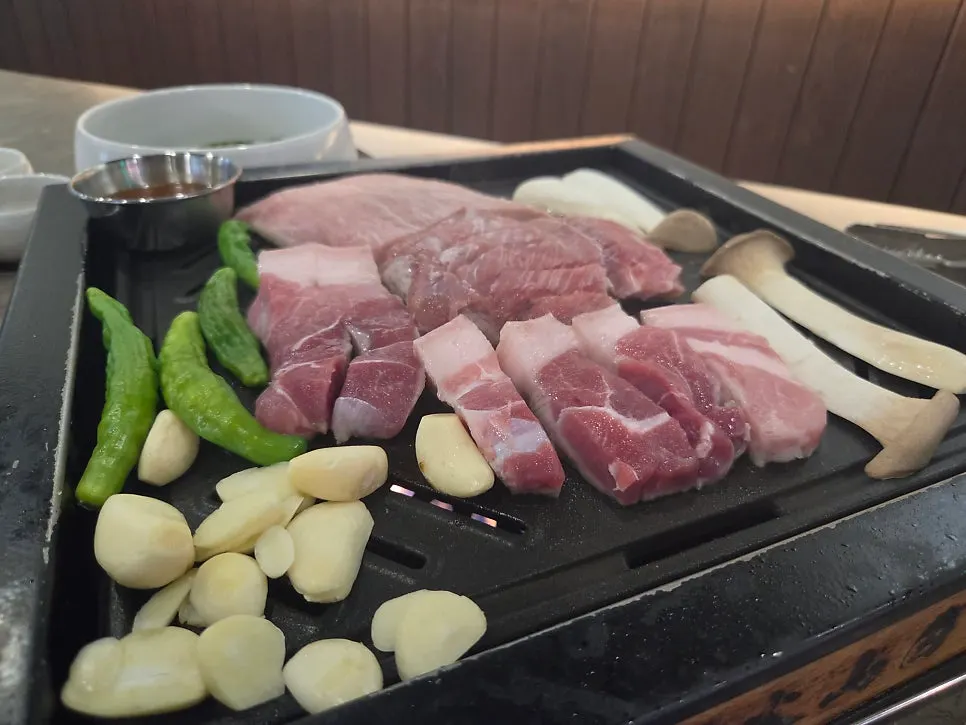 새송이버섯 고추 마늘이 함께 담긴 고기 접시