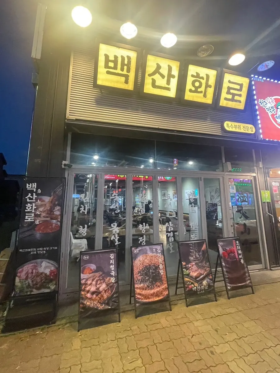 검은색 외벽에 큰 간판이 걸린 백산화로 청주점 외관