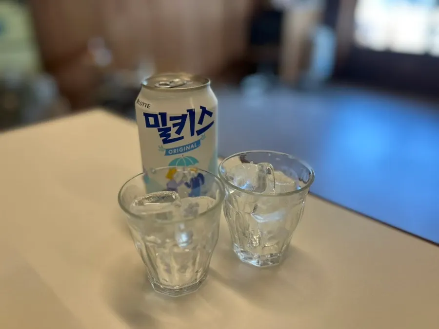 Individually wrapped utensils next to an ordered Milkis drink