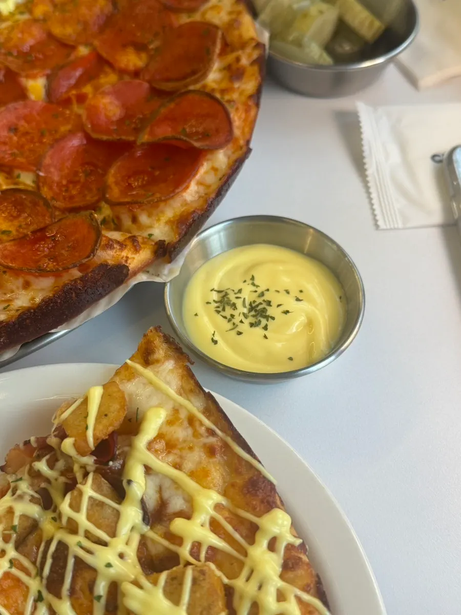 Pepperoni pizza dipped in garlic sauce