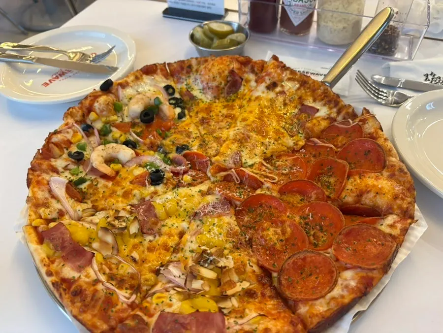 Full shot of the pizza divided into four flavors