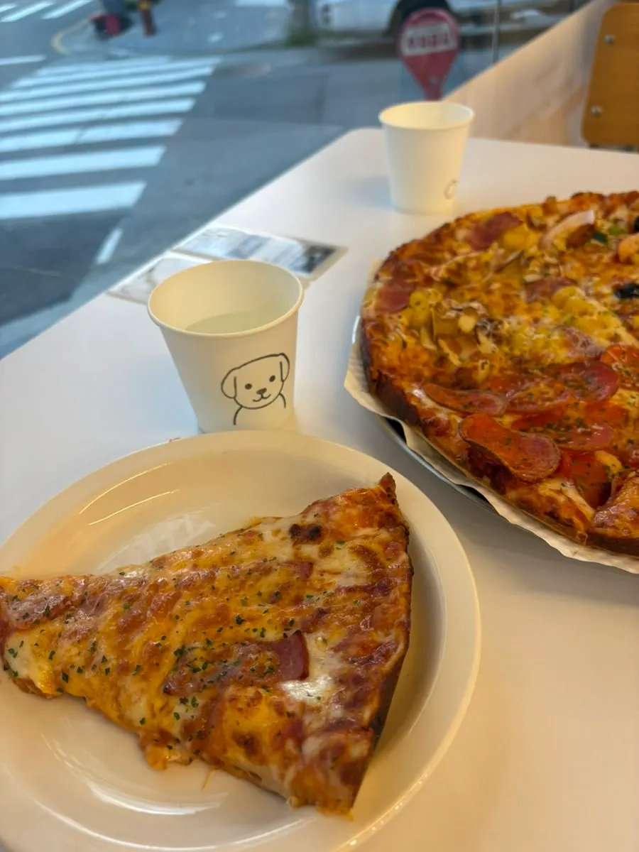 A slice of pizza enjoyed with a drink