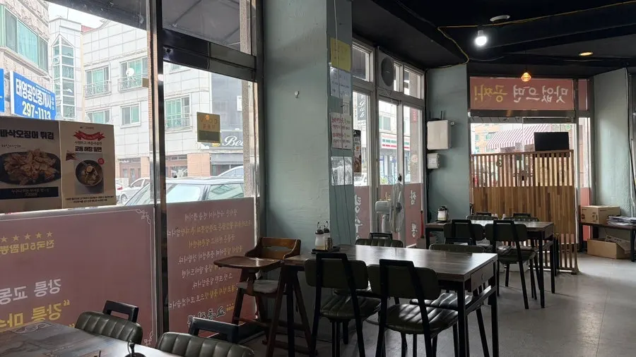 Interior of Gyodong Jjamppong with wood tables for four arranged in a row