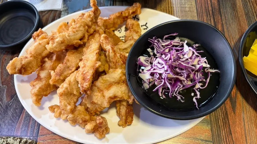 Plate of mini glutinous sweet-and-sour pork with sauce served separately