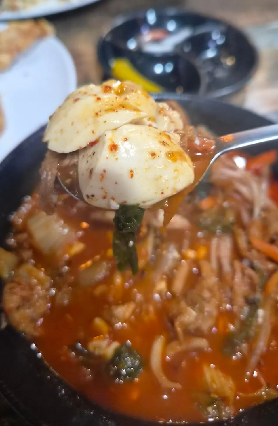 スプーンに乗せたスンドゥブとチャンポンスープ