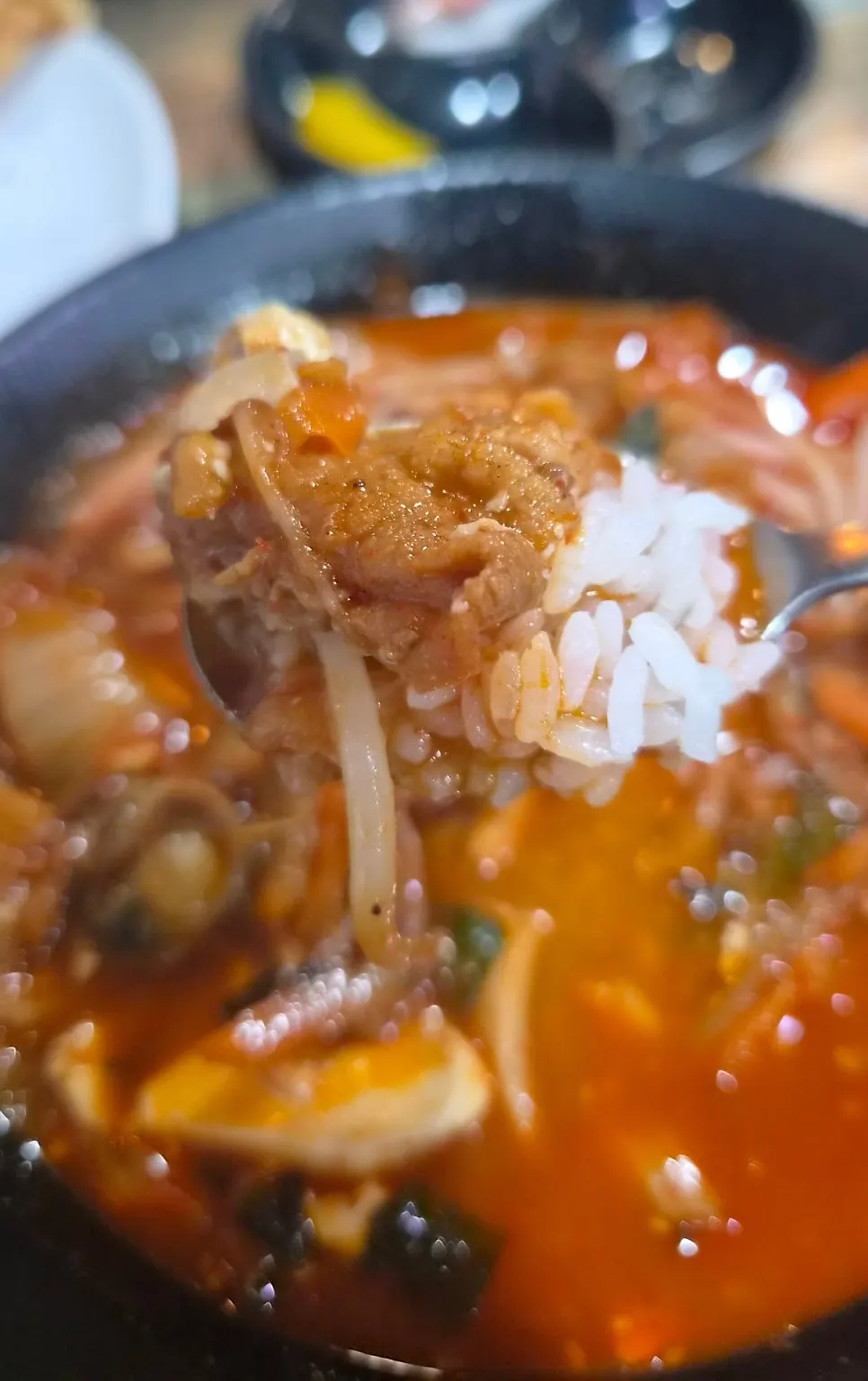 スープに浸したご飯にスンドゥブを乗せた一口