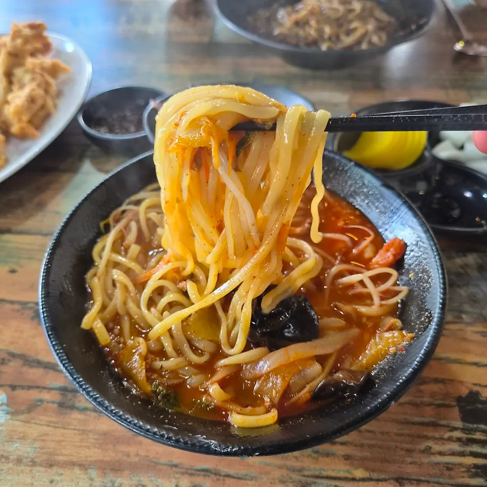 Chewy noodles lifted out of the Gyodong Jjamppong bowl