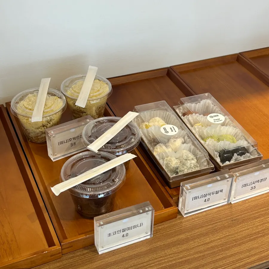 Pumpkin injeolmi and chocolate injeolmi displayed with three-color dutteok and gyeongdan