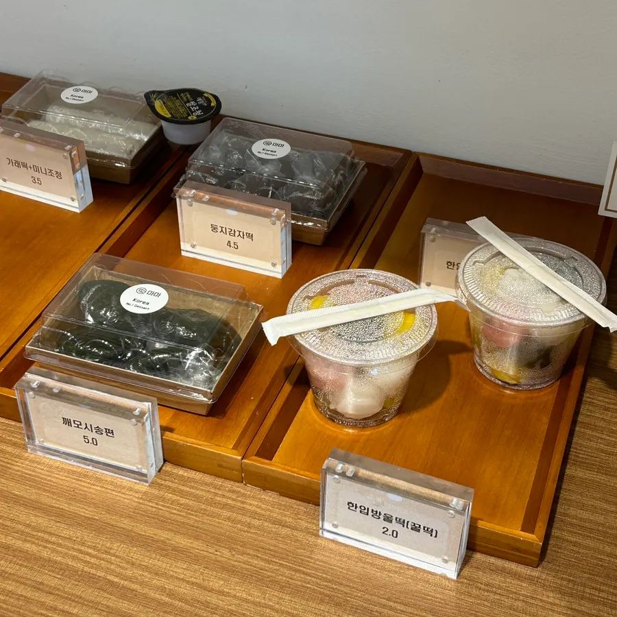 Bite-sized round tteok with individually wrapped gamjatteok and sesame-mosi songpyeon