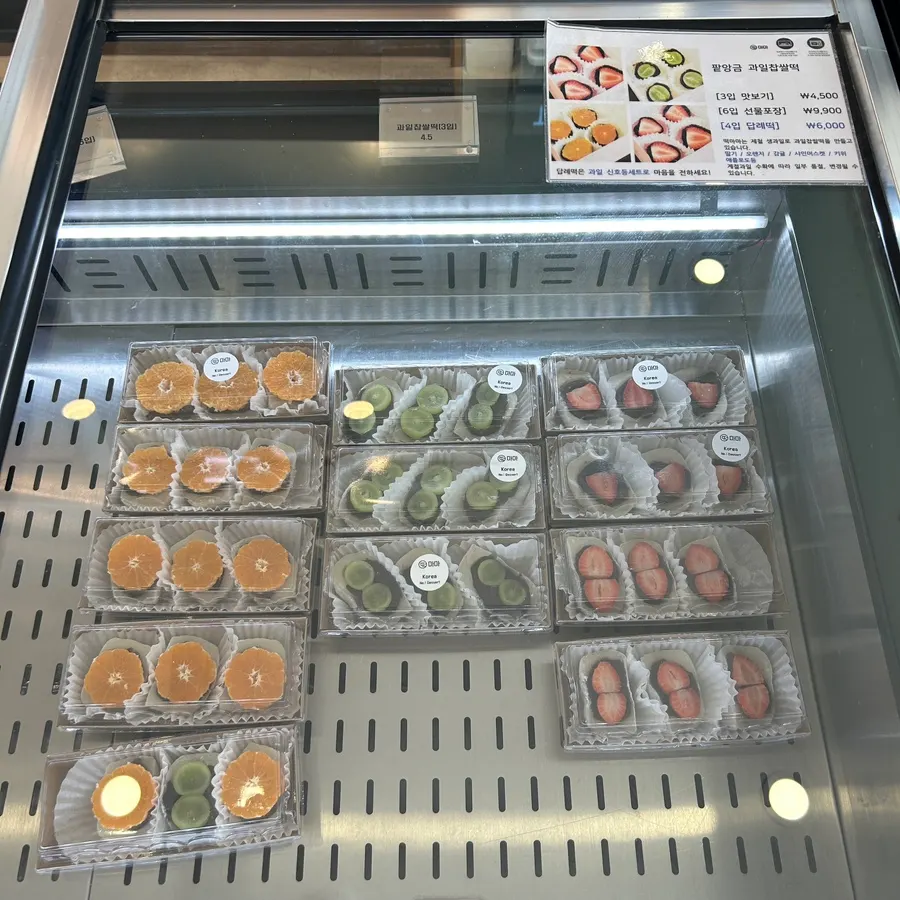 Tangerine, shine muscat, and strawberry fruit chapssaltteok on display