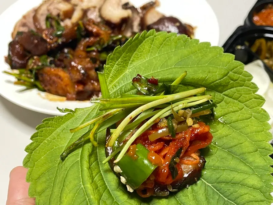 쌈채소에 족발을 올려 싸 먹는 모습