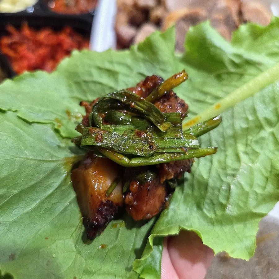 A piece of jokbal topped with chive namul